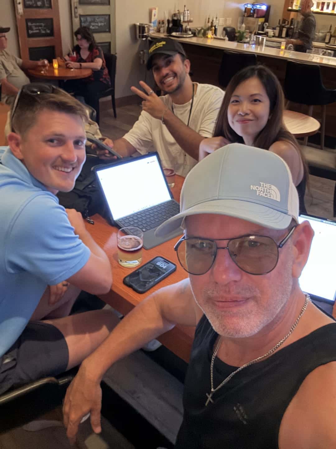 HavenStone team members and business owners talking around a laptop at a cafe table